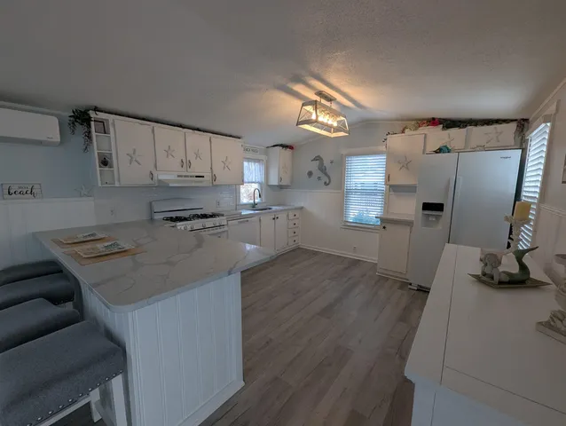 a kitchen with stainless steel appliances a stove a sink a refrigerator and cabinets