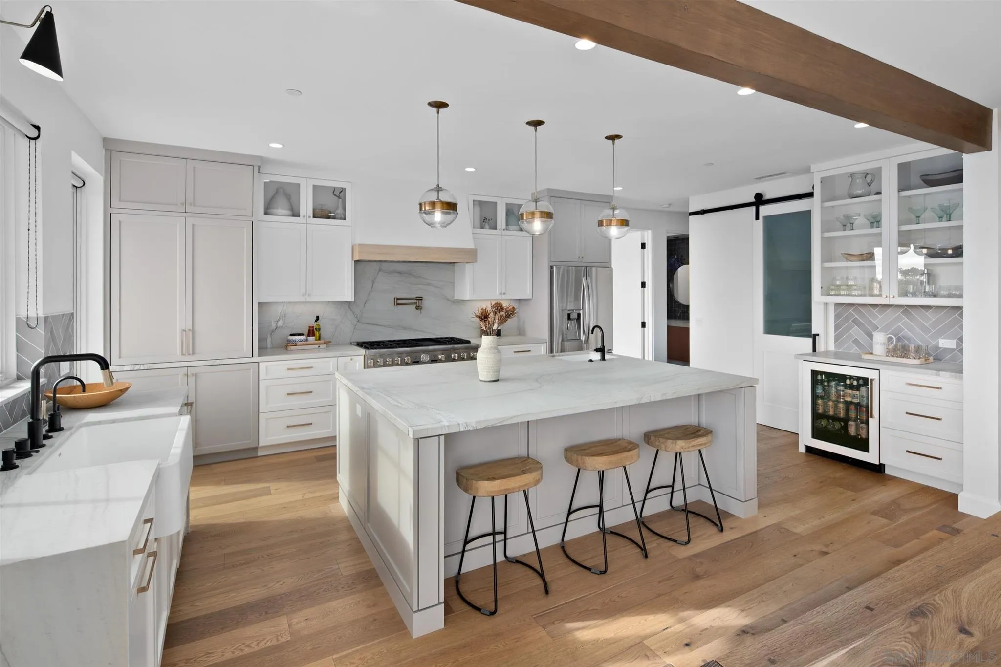 425 South Rios Avenue Solana Beach, CA 92075 - Photo 11 of 50 a kitchen with kitchen island a stove a sink a refrigerator and white cabinets with wooden floor