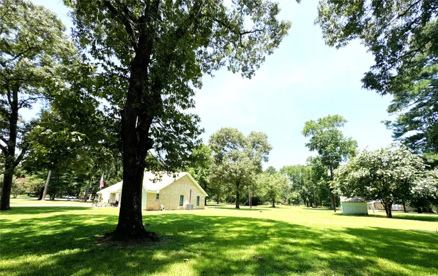 a big yard with lots of green space and trees