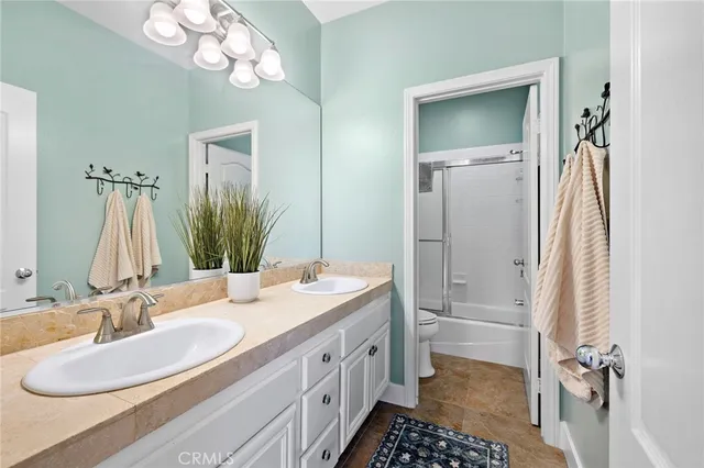 a bathroom with a double vanity sink a mirror and a shower