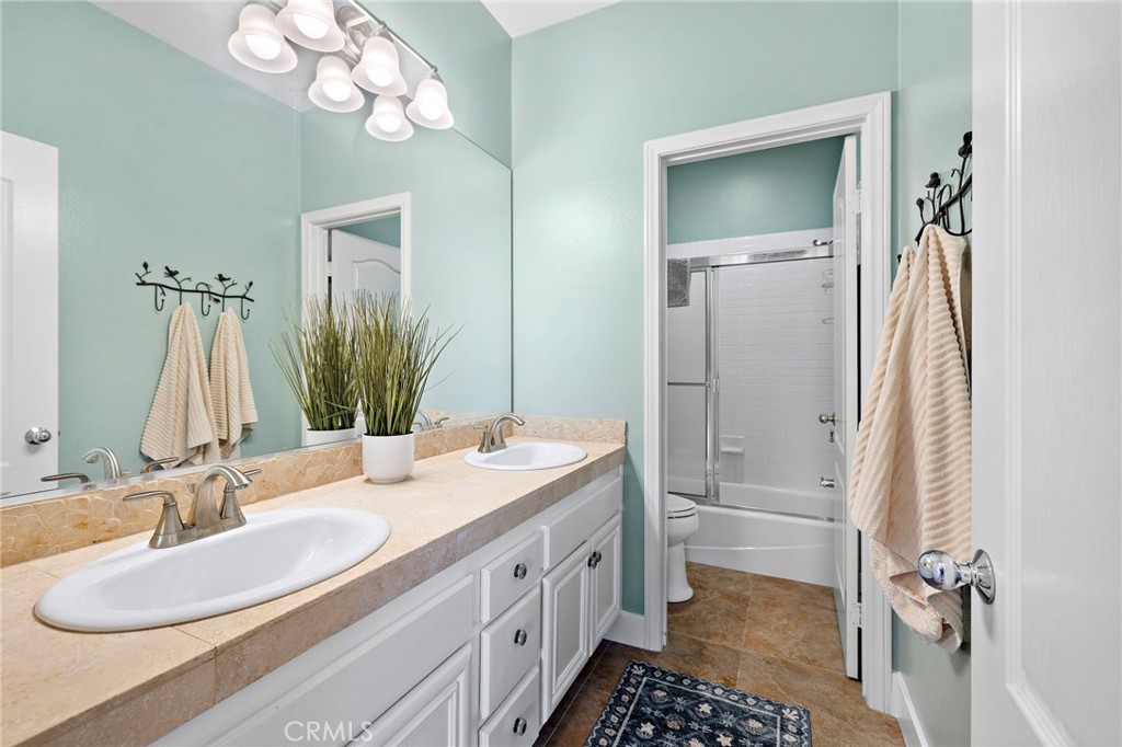 19361 Jasper Hill Road Lake Forest, CA 92679 - Photo 14 of 37 a bathroom with a double vanity sink a mirror and a shower
