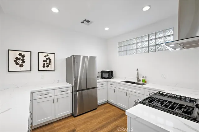 a kitchen with white cabinets and stainless steel appliances