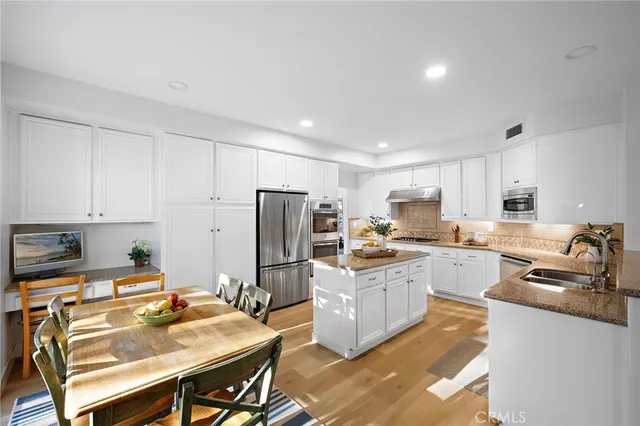 a kitchen with refrigerator cabinets and wooden floor