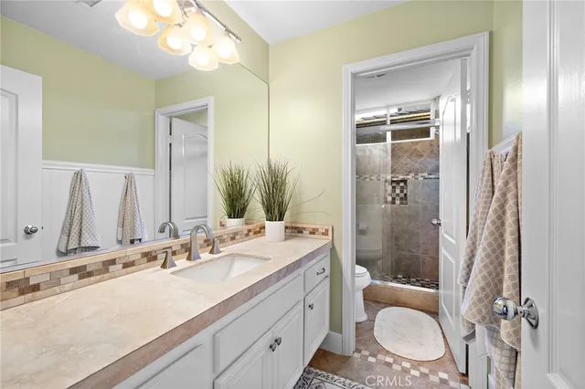a bathroom with a sink vanity granite toilet and a mirror