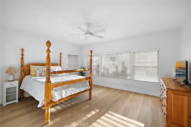 a bedroom with a bed and a flat tv screen on the dresser