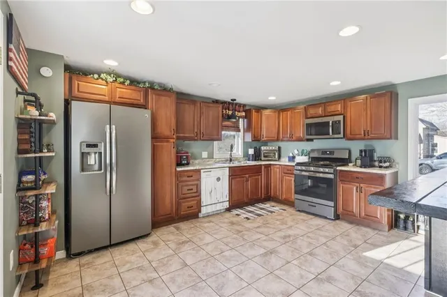 a kitchen with stainless steel appliances granite countertop a refrigerator sink and cabinets