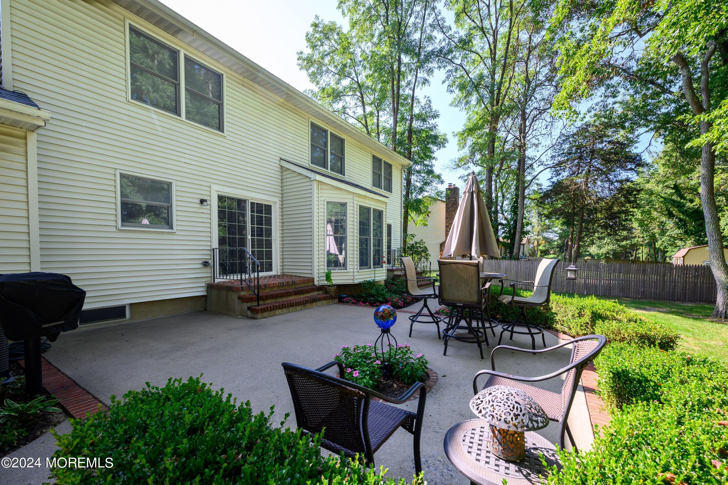 14 Spicy Pond Road Howell, NJ 07731 - Photo 23 of 35 a view of a patio with table and chairs potted plants and a large tree