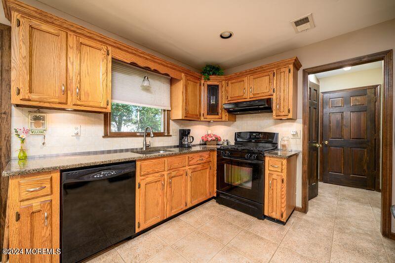 14 Spicy Pond Road Howell, NJ 07731 - Photo 3 of 35 a kitchen with stainless steel appliances granite countertop wooden cabinets a sink and a stove