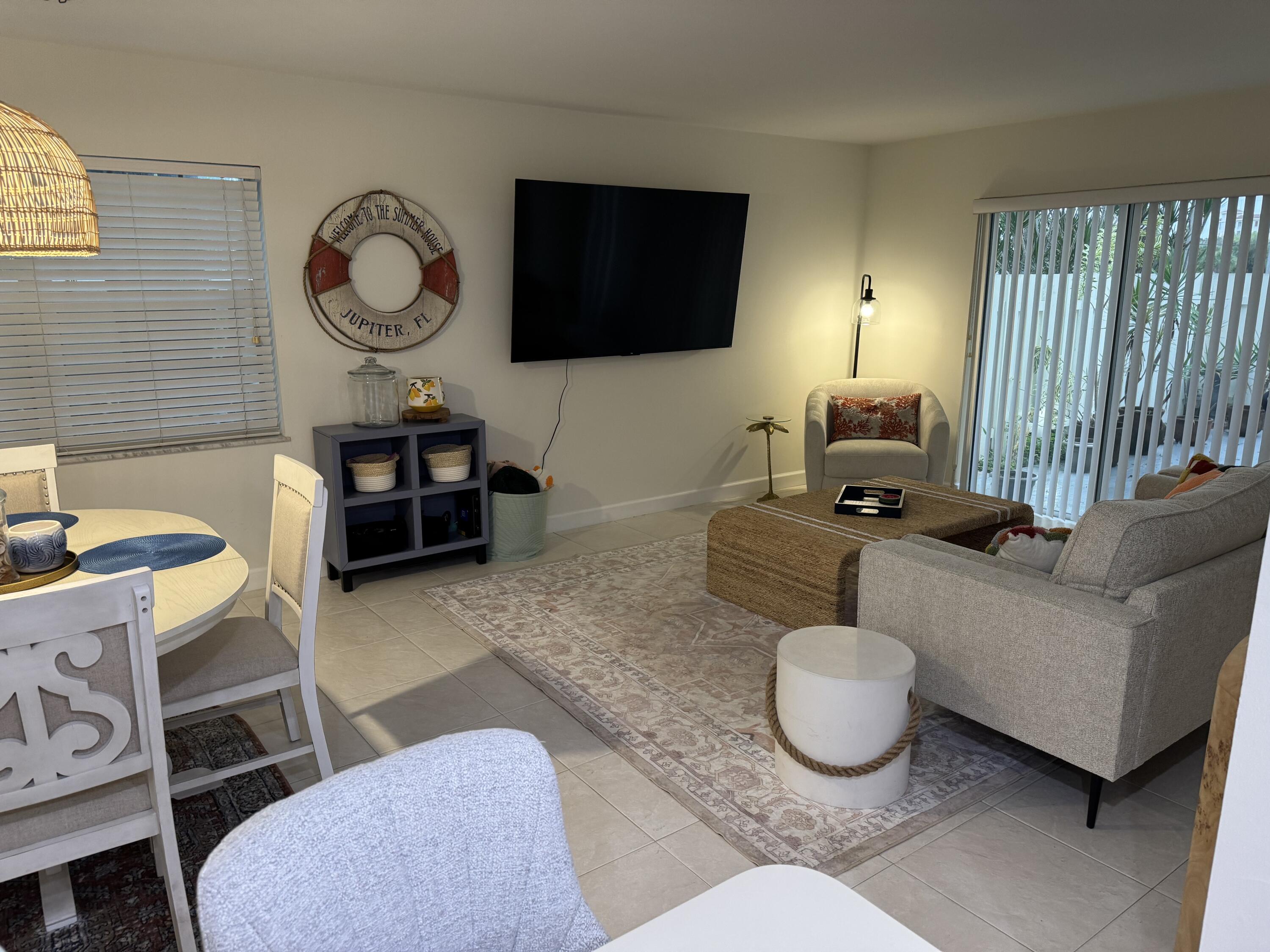 176 Seabreeze Circle Jupiter, FL 33477 - Photo 13 of 28 a living room with furniture a flat screen tv and a window