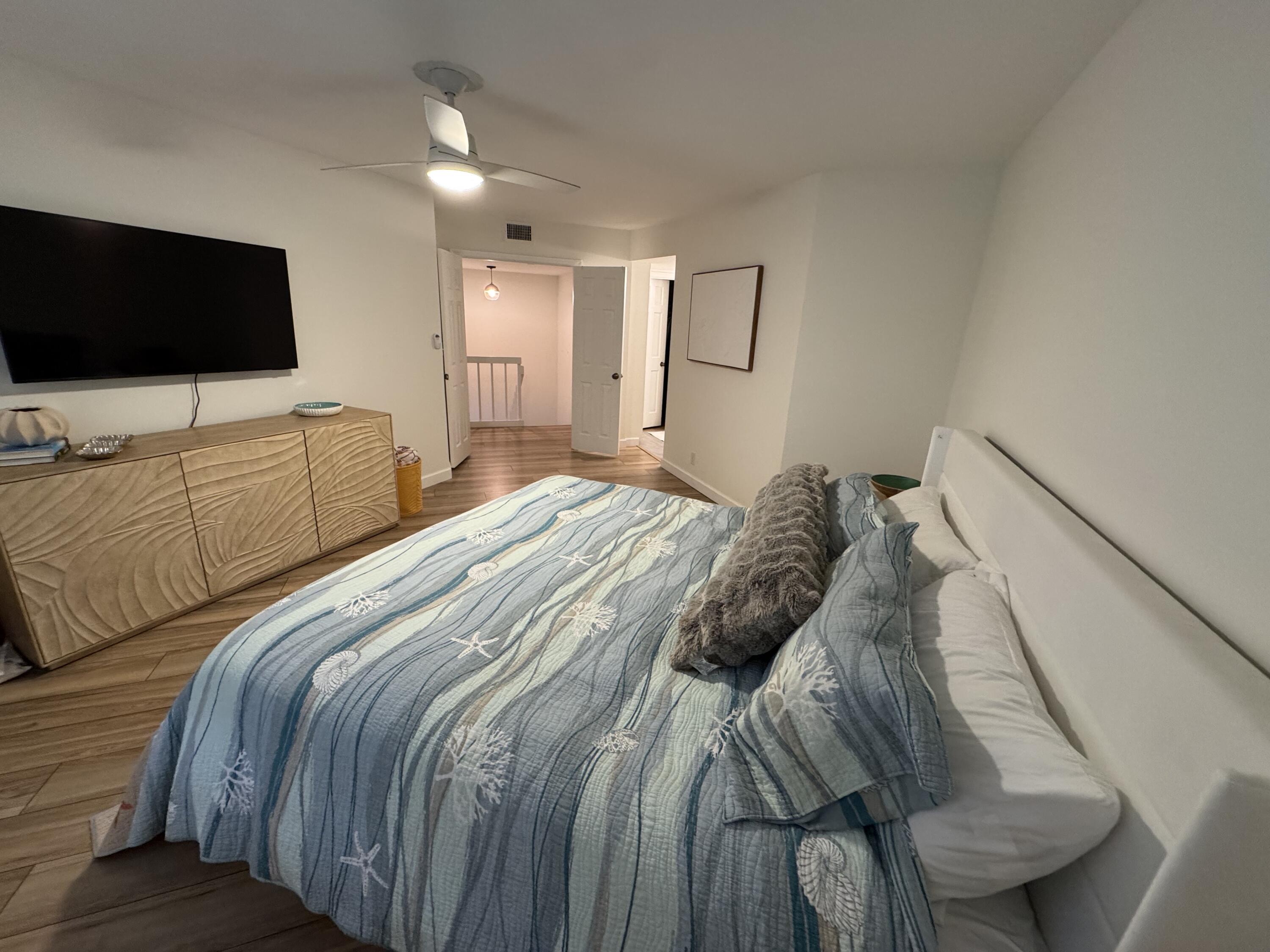 176 Seabreeze Circle Jupiter, FL 33477 - Photo 20 of 28 a bedroom with a bed and a flat screen tv