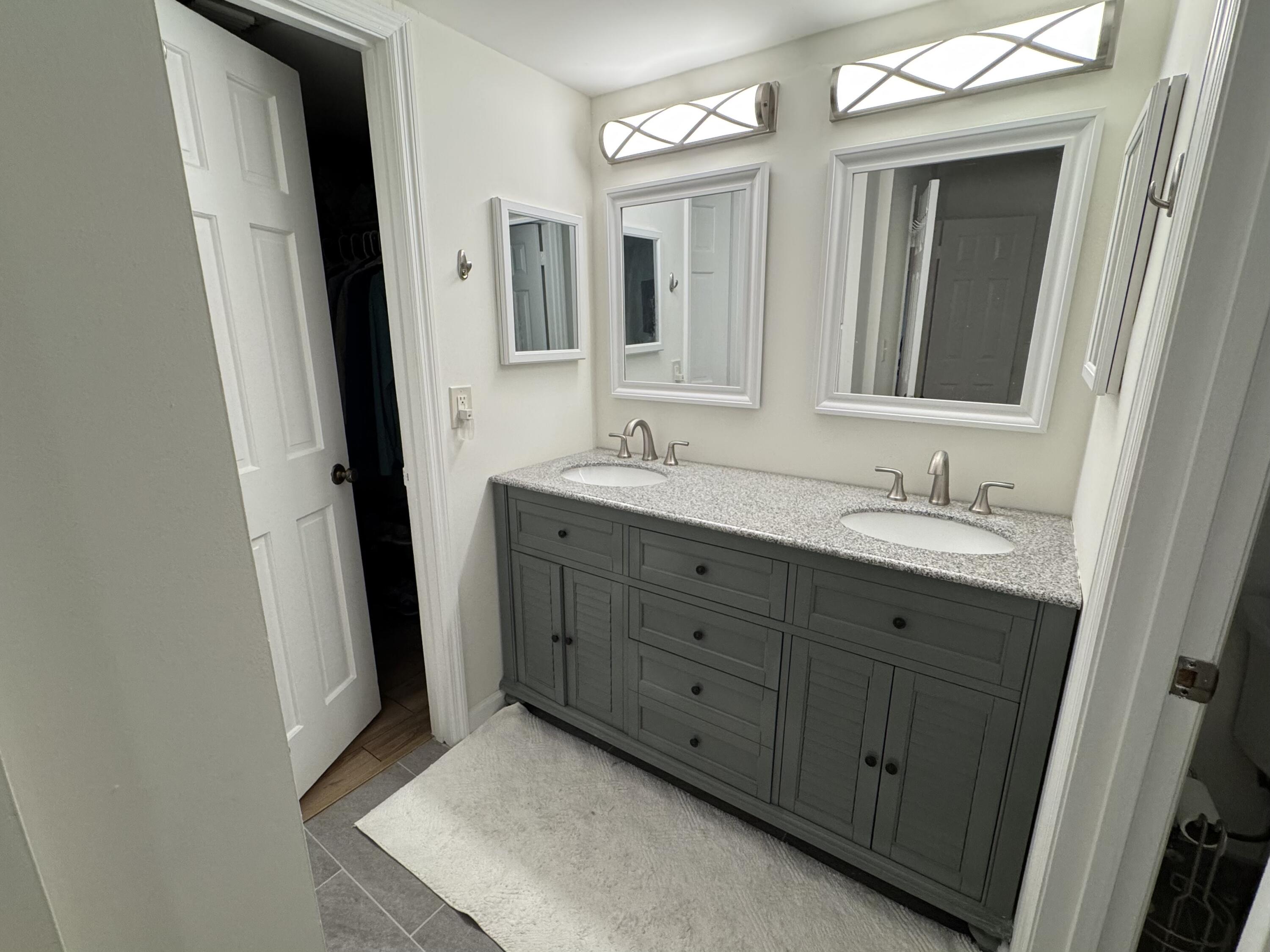176 Seabreeze Circle Jupiter, FL 33477 - Photo 21 of 28 a bathroom with a double vanity sink and mirror