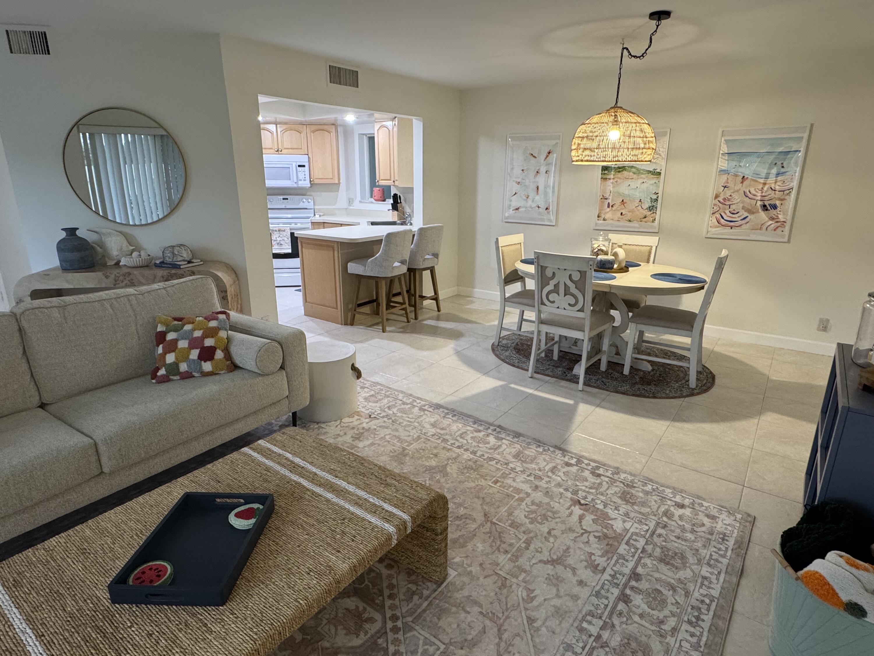 176 Seabreeze Circle Jupiter, FL 33477 - Photo 10 of 28 a living room with furniture rug and a chandelier