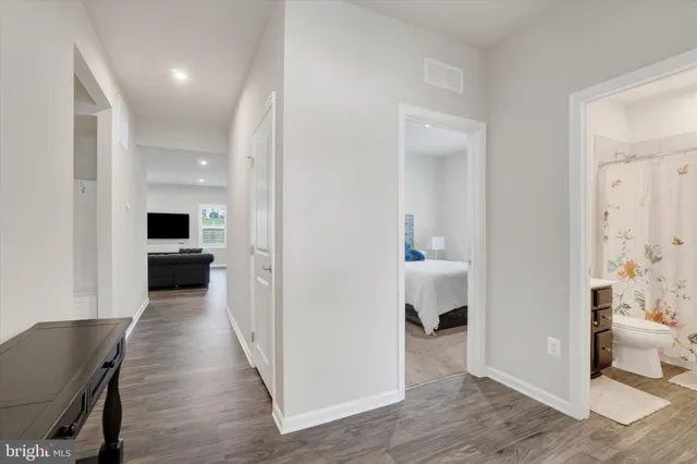 a view of a hallway with wooden floor and a living room