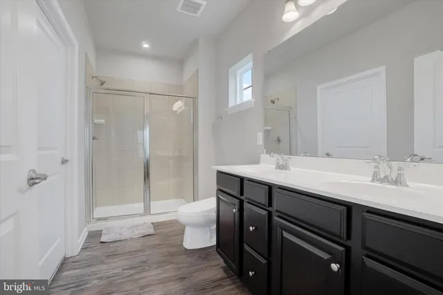 a bathroom with a double vanity sink toilet and shower