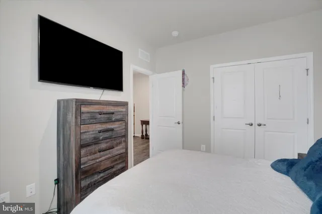 a bedroom with a flat screen tv and dresser