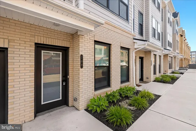 front view of a brick house with potted plants