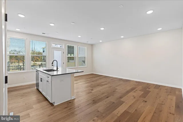 a large kitchen with stainless steel appliances granite countertop a large stove a sink and a large mirror with wooden floor