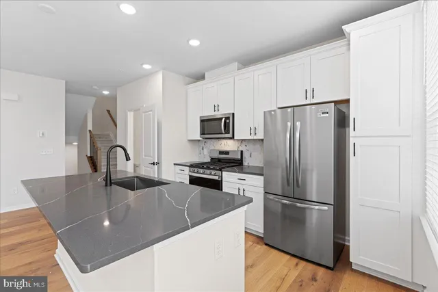 a kitchen with stainless steel appliances granite countertop a refrigerator a stove a sink a microwave and with a refrigerator