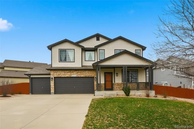 a view of a house with a yard and large tree