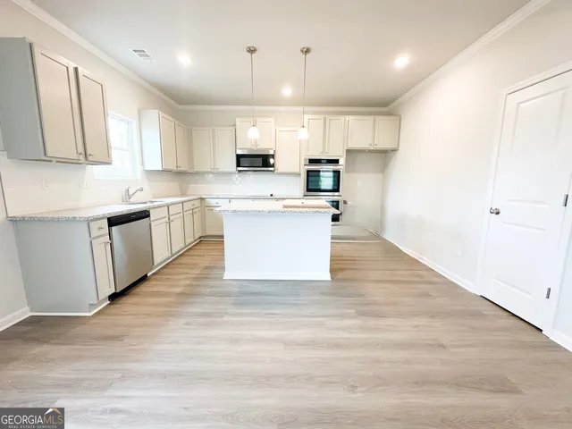 a large kitchen with cabinets and wooden floor