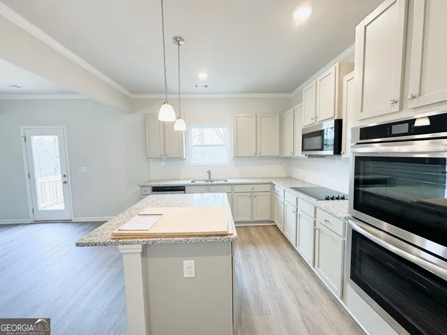 a kitchen with a sink dishwasher a stove and a microwave oven with wooden floor
