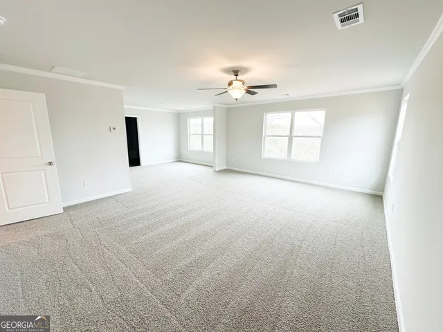 an empty room with windows and ceiling fan