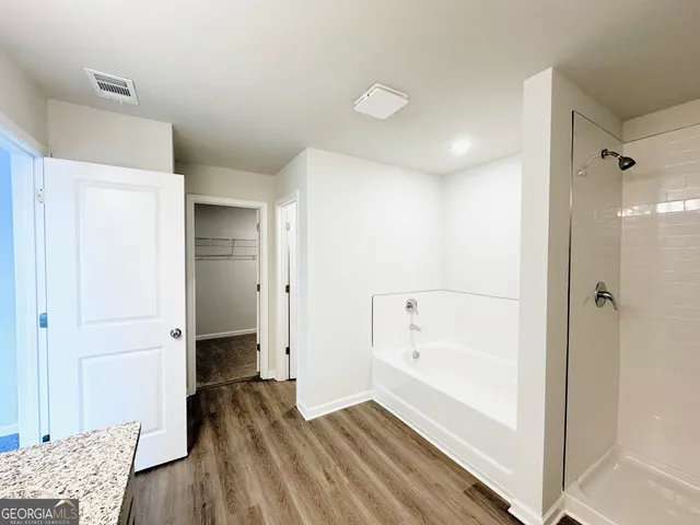 a bathroom with a bathtub and a walk in closet