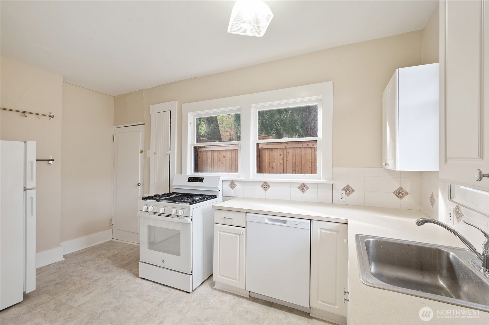 1425 Palm Avenue Southwest Seattle, WA 98116 - Photo 17 of 23 a kitchen with white cabinets sink and white appliances