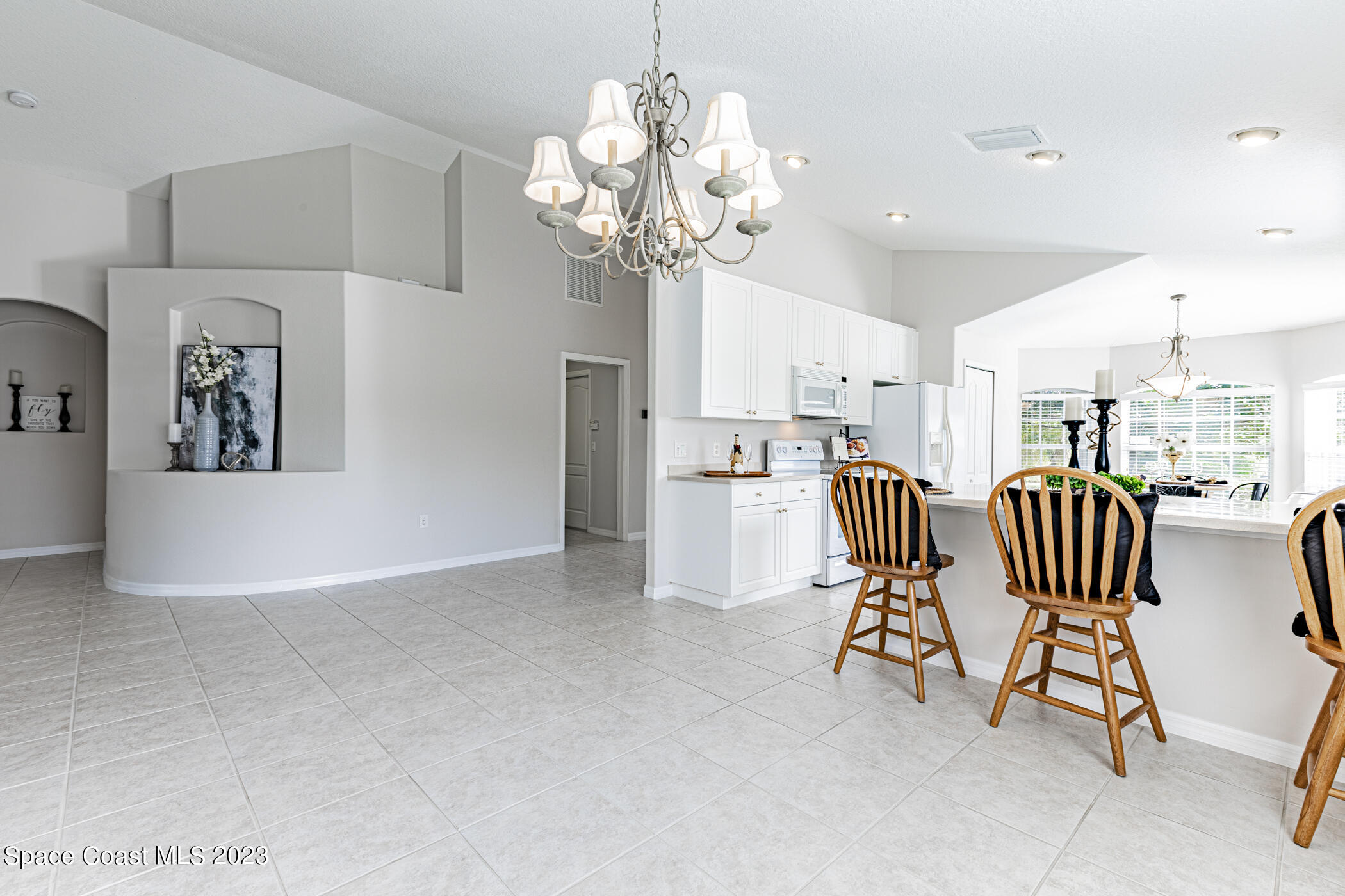 3102 Galindo Circle Melbourne, FL 32940 - Photo 12 of 31 a dining room filled chandelier and kitchen view