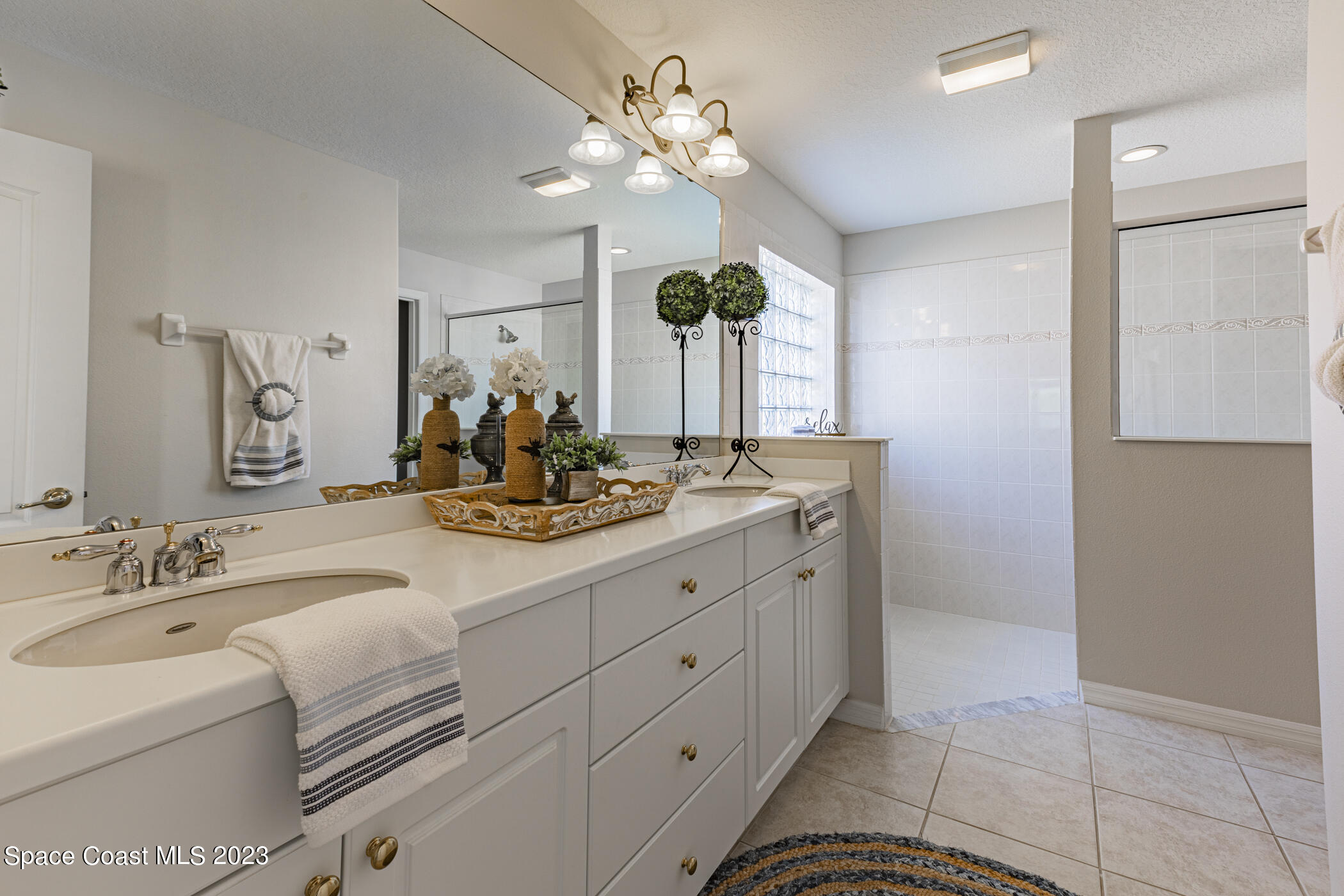 3102 Galindo Circle Melbourne, FL 32940 - Photo 23 of 31 a bathroom with a double vanity sink and a mirror