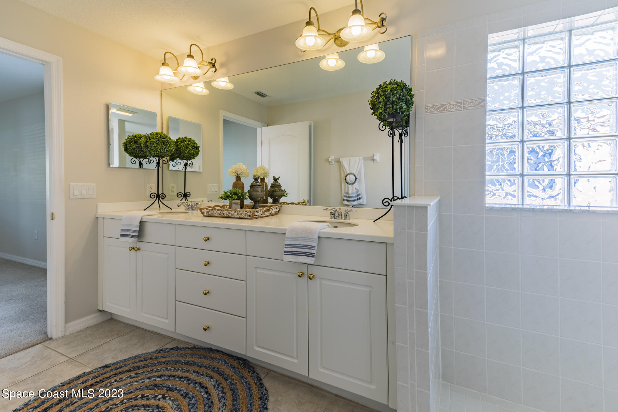 3102 Galindo Circle Melbourne, FL 32940 - Photo 28 of 31 a spacious bathroom with a double vanity sink and a mirror