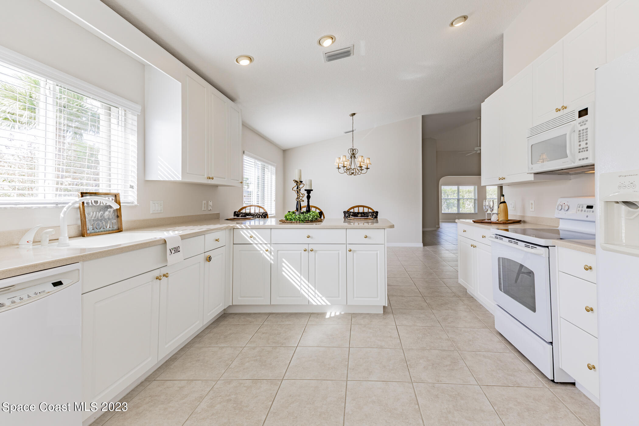 3102 Galindo Circle Melbourne, FL 32940 - Photo 9 of 31 a kitchen with white cabinets a sink and white appliances