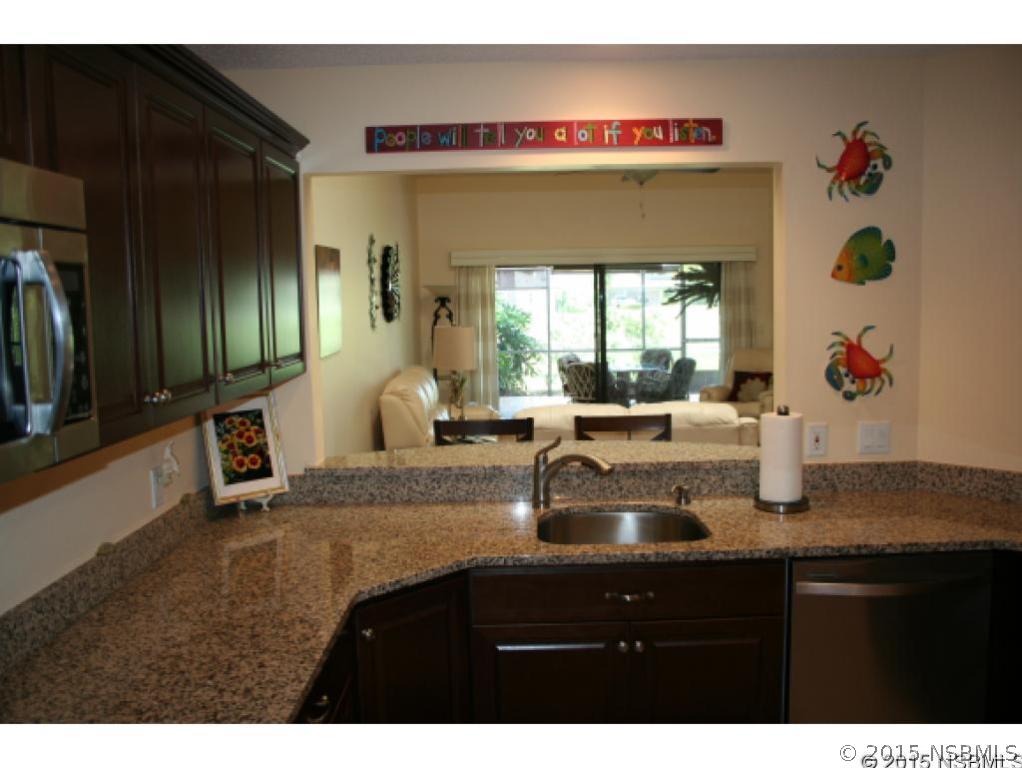 1993 Rutgers Place, Unit 43 Port Orange, FL 32128 - Photo 9 of 24 a kitchen with a sink and a refrigerator