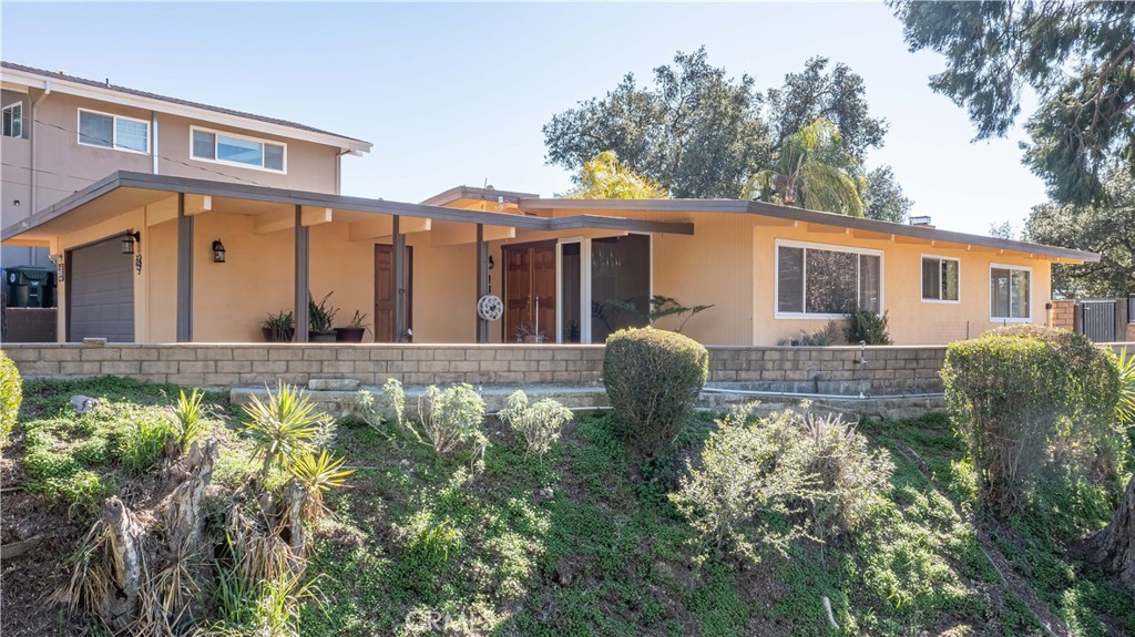 a front view of house with yard and trees in the background