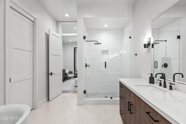 a bathroom with a tub sink shower and mirror