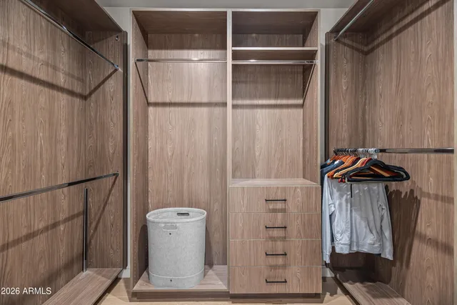 a view of walk in closet with clothes and shoes