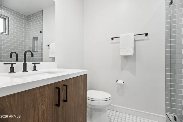 a bathroom with a sink a toilet and mirror