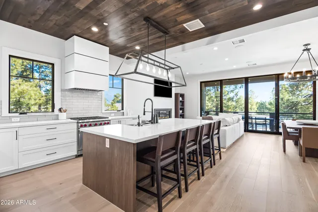 a kitchen with a table chairs stove and wooden floor