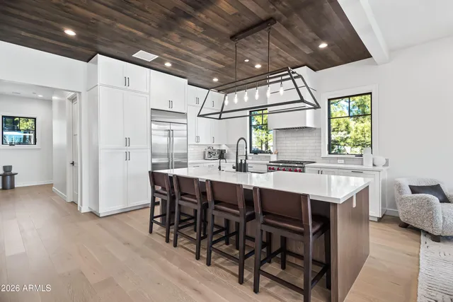 a kitchen with a sink and chairs