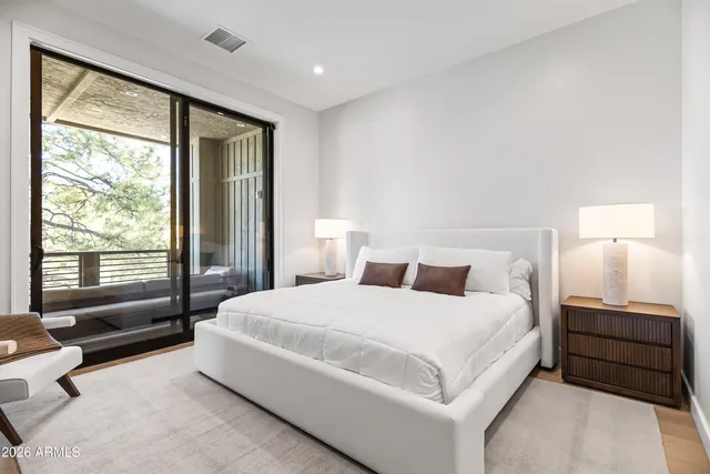 a bedroom with a bed and a large window