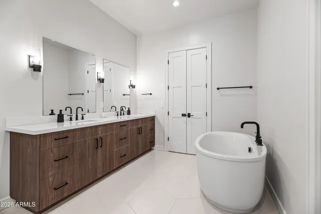 a spacious bathroom with a tub sink and mirror