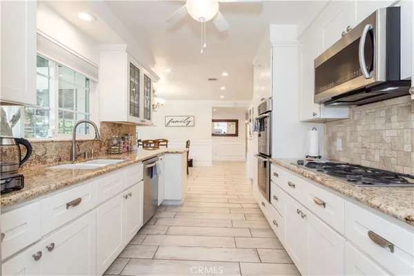 a large kitchen with stainless steel appliances granite countertop a stove and a sink
