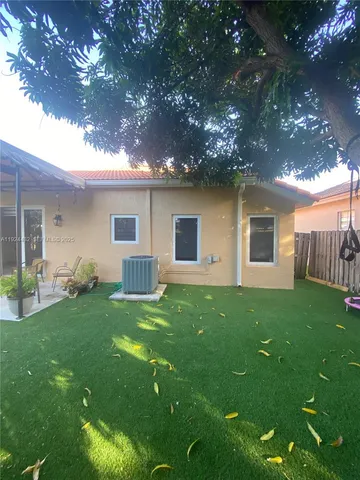 a view of a backyard with table and chairs and a yard