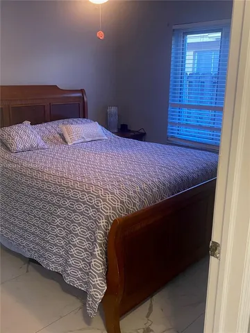 a bed sitting in a bedroom next to a wooden cabinet