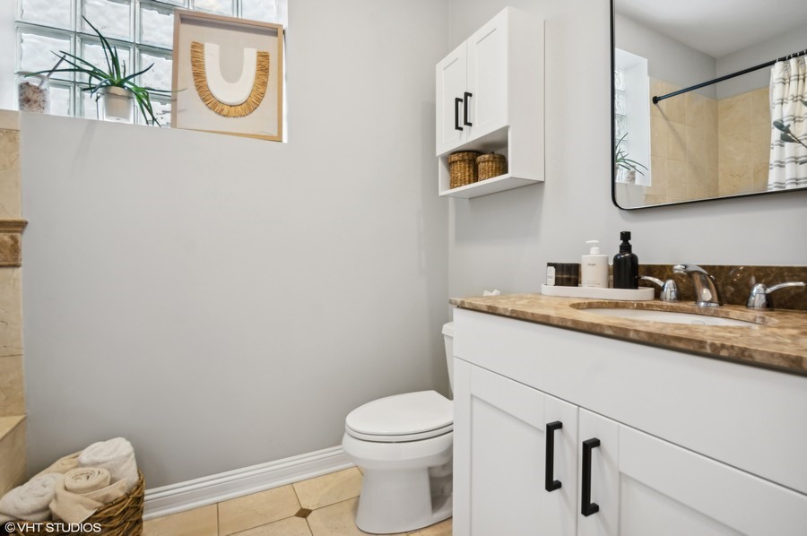 1411 West Chicago Avenue, Unit 3 Chicago, IL 60642 - Photo 14 of 17 a bathroom with a granite countertop toilet sink and mirror