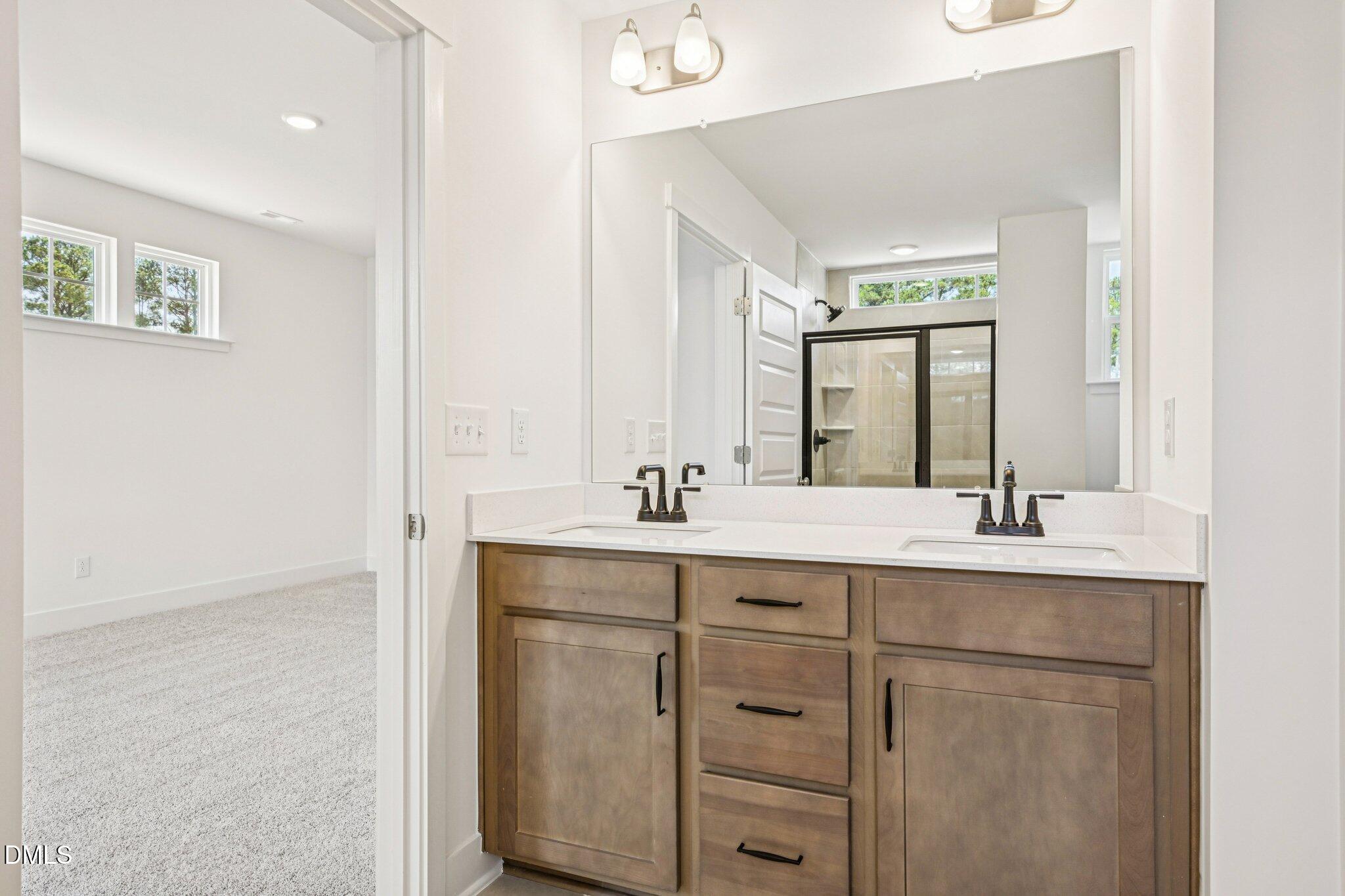 10905 Bayflower Way Raleigh, NC 27617 - Photo 15 of 49 a bathroom with a granite countertop sink and a mirror
