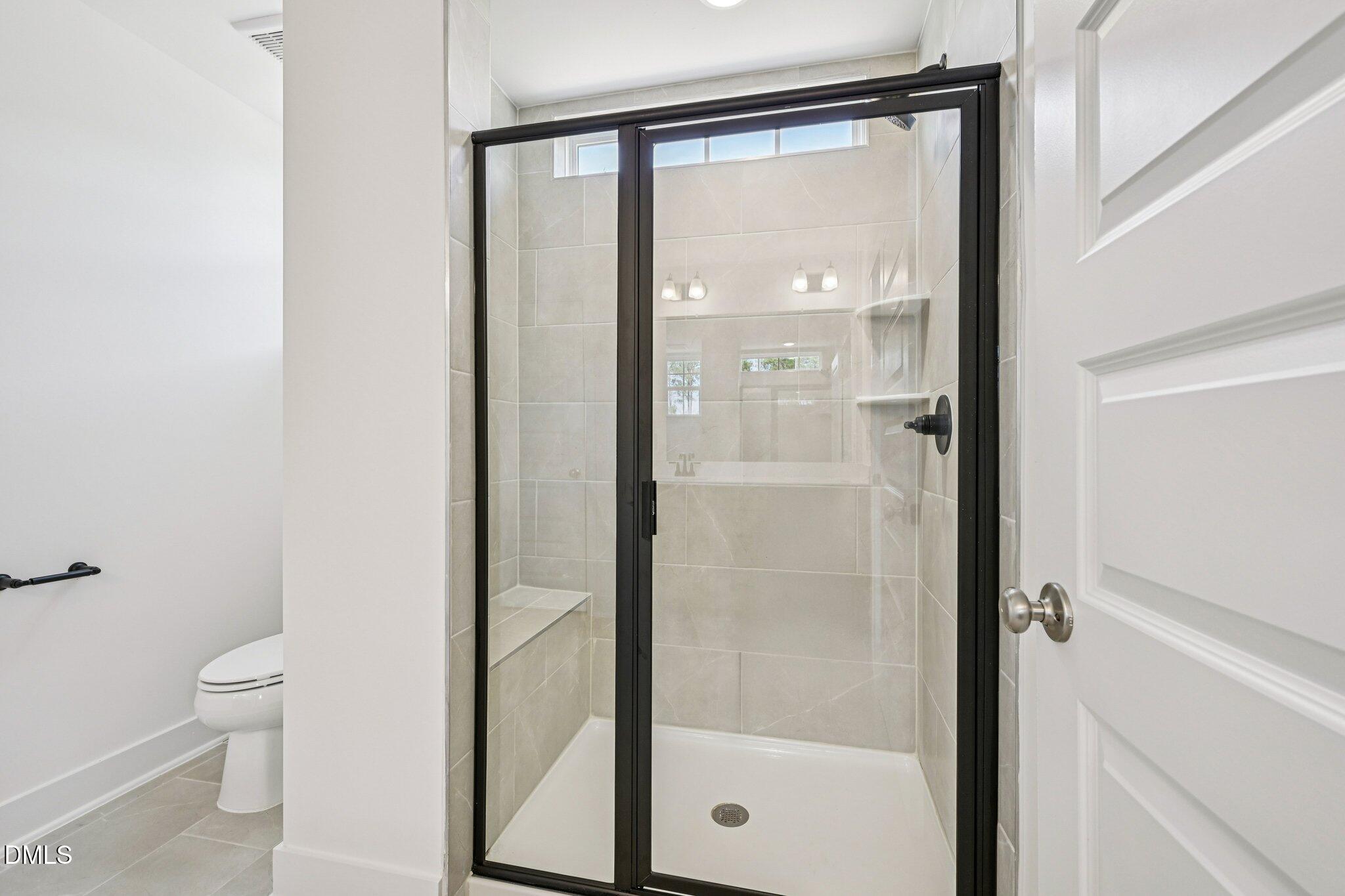 10905 Bayflower Way Raleigh, NC 27617 - Photo 17 of 49 a bathroom with a shower a toilet and a glass window