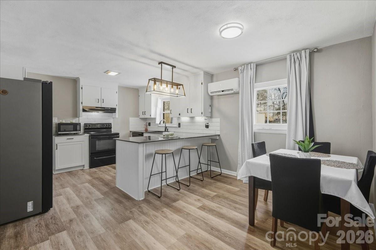 2563 Marble Street Newton, NC 28658 - Photo 15 of 40 a kitchen with refrigerator cabinets dining table and chairs