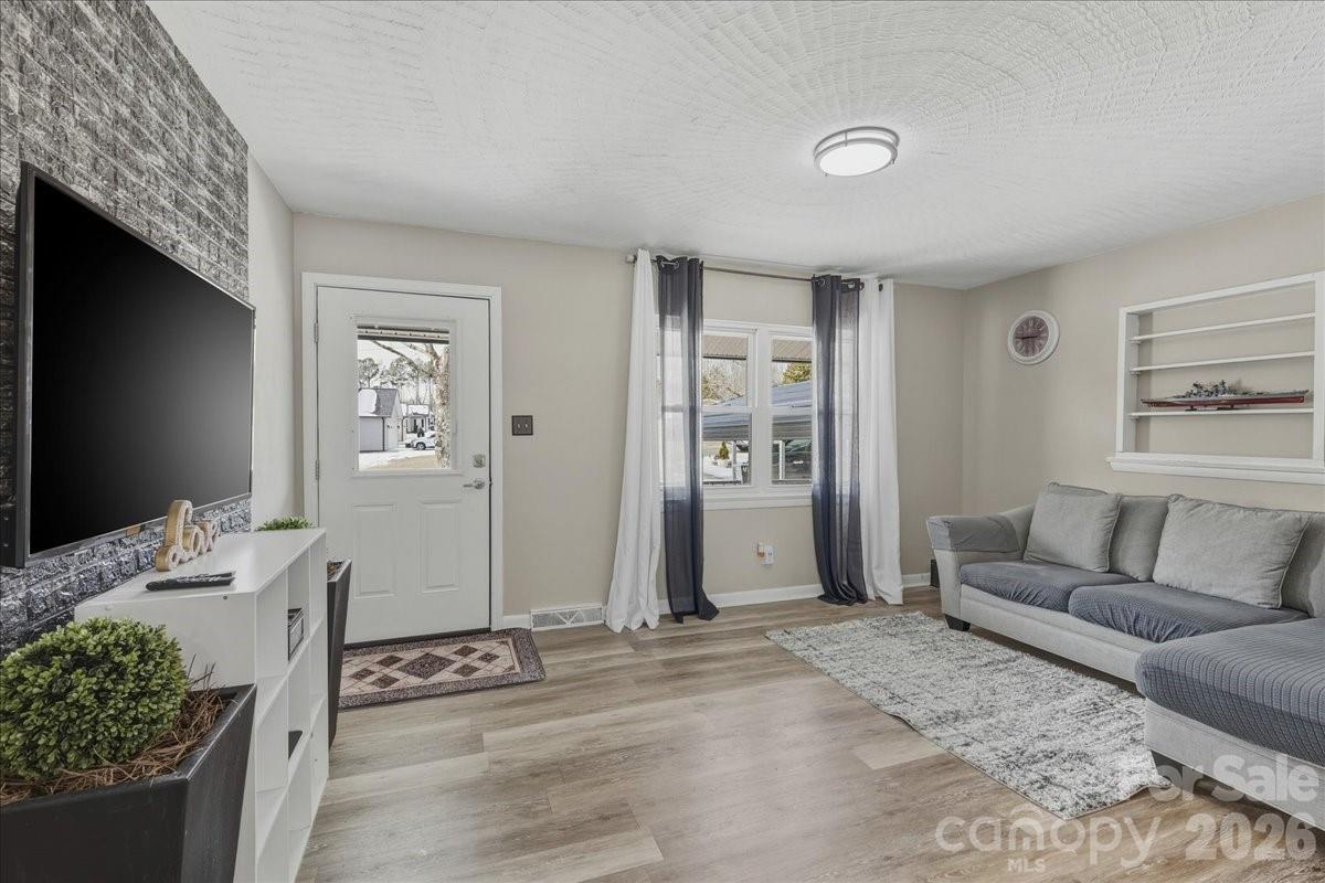 2563 Marble Street Newton, NC 28658 - Photo 10 of 40 a living room with furniture a flat screen tv and a fireplace