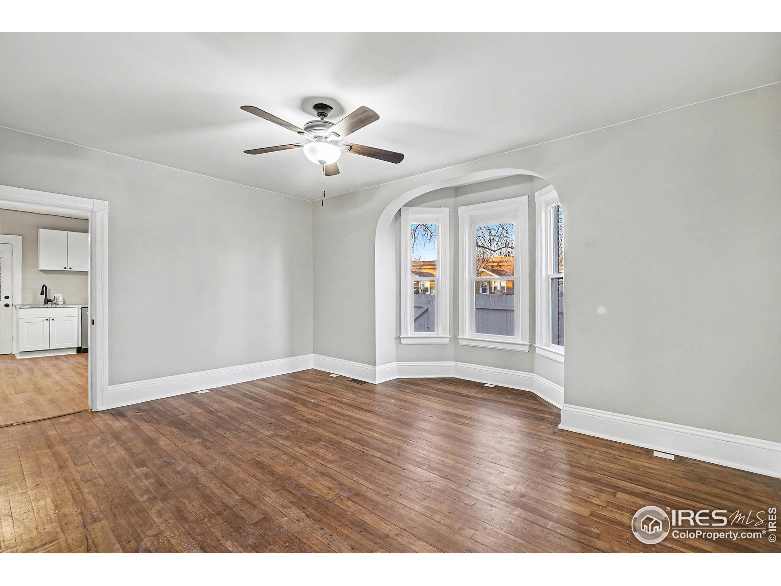 1330 8th Street Greeley, CO 80631 - Photo 11 of 27 a view of an empty room with window and wooden floor